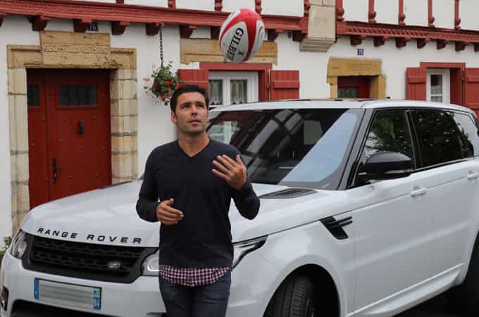 Dimitri Yachvili, ballon à la main, près d'un Range Rover Sport